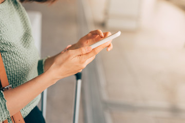 Young woman using phone to check her flight at the airport.