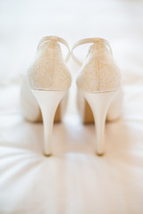 Back side of a bride wedding shoes. White bride wedding shoes.