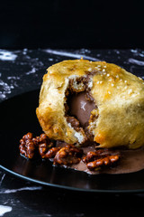 Fried Ice Cream with Chocolate and Roasted Walnuts in Dark Black Plate.