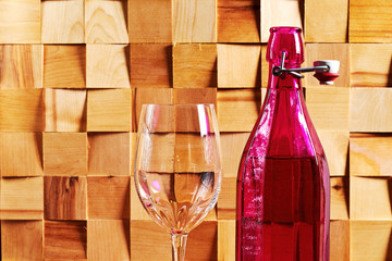 Old pink wine bottle and a wine glass in the wooden bar interior. Old pirate treasures from the...