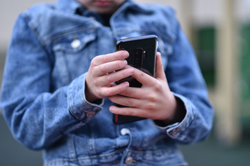 Closeup of Teenager holding a phone in his hand