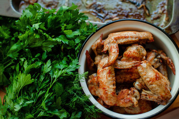 Barbecue chicken wings. Oven baked chicken wings with dill and parsley. Plate of fried chicken wings. Top view