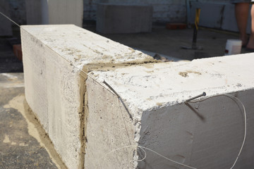 Setting up a level line, string line for bricklaying using a nail or a pin and a string to ensure the built brick, block wall is straight and level.