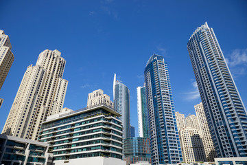 Fototapeta na wymiar Dubai Marina skyscrapers, low angle view in a sunny day, clear blue sky in Dubai