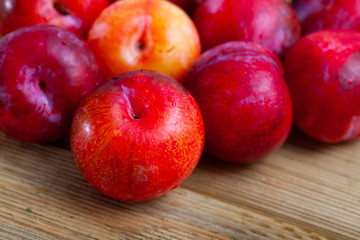 Fototapeta na wymiar Tasty ripe red plum on a wooden surface