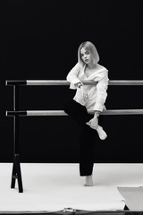 Naklejka premium Portrait of a pretty blonde woman standing looking to the camera with crossed hands in white shirt 