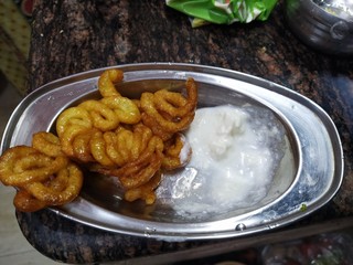 Fresh and crispy sweet dish of West India- Jalebi. Delicious street side snack popular in black and white colors.