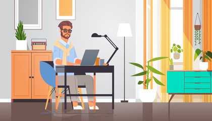 Fototapeta premium freelancer using laptop man sitting at workplace self-isolation coronavirus pandemic quarantine concept modern cabinet interior full length horizontal vector illustration