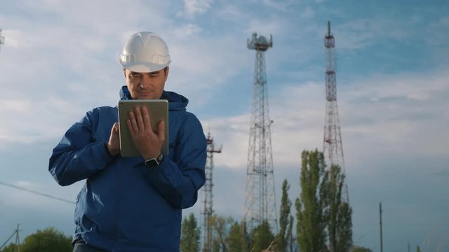 A telecommunications engineer working on a digital tablet records data for maintenance of the telecommunications network. Design, repair and installation of satellite and telecommunications networks.