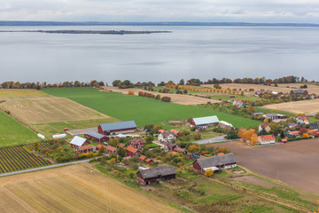 Obraz premium View of Lake Vattern with a picturesque little Swedish village on the coast photographed from the fortress Brahehus in Granna, Jonkoping, Sweden.