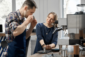 young man and woman make espresso coffee. guy and girl enjoy the smell of coffee. People make aromatic coffee. Coffee school.