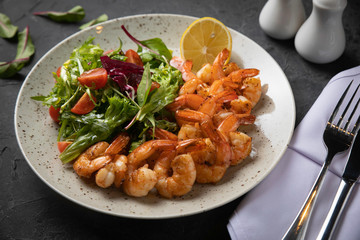 salad with shrimp and avocado on black background