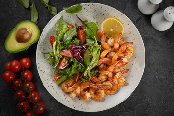 salad with shrimp and avocado on black background