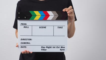Hand is holding clapper board or movie slate and standing on white background. it is used in video...