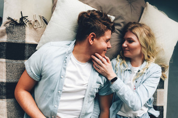 A young couple of lovers lie on the bed.