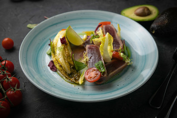 tuna salad and avocado on black background