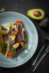 tuna salad and avocado on black background