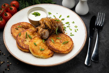 pancakes with sauce and mushrooms on a dark background

