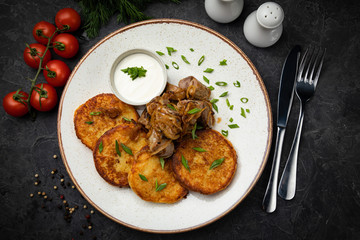 pancakes with sauce and mushrooms on a dark background
