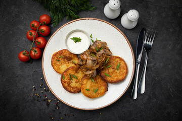 pancakes with sauce and mushrooms on a dark background
