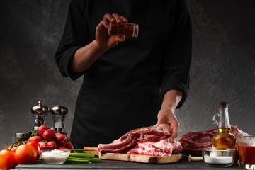 Cooking fresh pork ribs. For roasting and cooking. Chef sprinkles with seasoning for roasting. Classic American dish