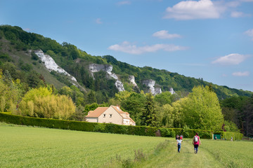 People hiking near a cliff close to river Seine and the village of La Roche Guyon in Vexin regional...