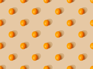 top view of ripe oranges on beige background, seamless pattern