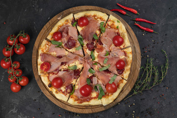 Italian pizza with tomatoes on a black background