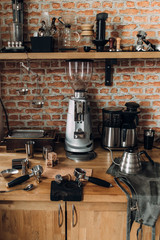 Accessories and items for coffee on a background of a brick wall. School barista. Equipment for cafes.