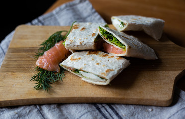 
Healthy food pita bread cutaway appetizer tartilla with soft cheese dill and lettuce on a wooden...
