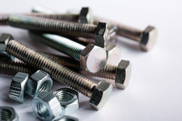 macro shot. Bolts and nuts lie on a white background. Close-up of parts for construction and repair