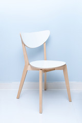 A white wooden backrest chair in a minimalist home. A white wooden dining table and chairs.