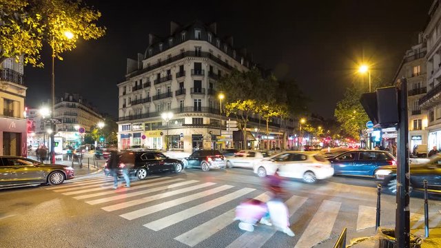 Cars driving a crowded Paris street at night timelapse