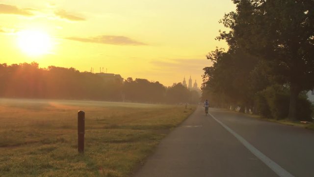 Cyclist riding a bike on commons during a beautiful foggy sunrise morning in Krakow
