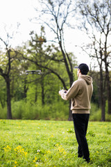 Young man operating a drone with remote control outdoors