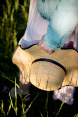 straw hat with black tape in the habds of a woman in the spring garden