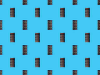 top view of sweet dark chocolate bars on blue colorful background, seamless pattern