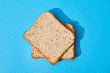 top view of fresh toast bread on blue colorful background