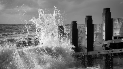 waves crashing against groynes in hove