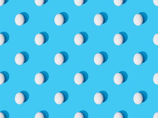 top view of fresh chicken eggs on blue background, seamless pattern