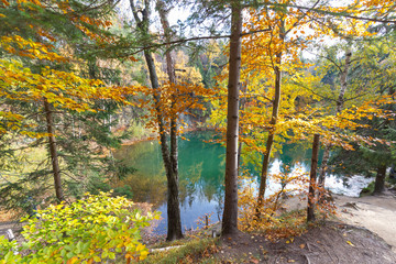 Jeziorko Turkusowe, niebieskie jeziorko, otoczone drzewami z jesiennymi liśćmi, Kolorowe Jeziorka w Rudawach Janowickich, Polska