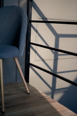 Close up of spiral staircase on black stone wall corner background. Black lobby interior rough concrete stairway with black steel handrail. Sunlight. Minimalist interior design.