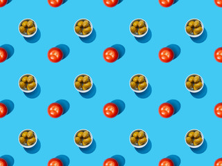 top view of olives in bowls and tomatoes on blue colorful background, seamless pattern