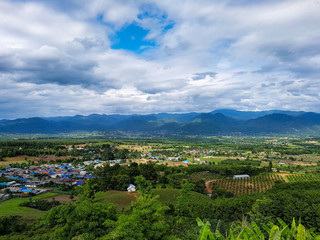 Fototapeta na wymiar White clouds pai village blue roofs houses fields plants nature outside mountains background warm sky chiang mai north