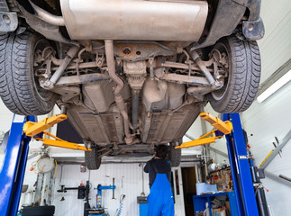 Inspection of the undercarriage of the car in the garage.  - obrazy, fototapety, plakaty