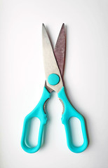 used metal scissors with blue plastic handles. isolated on a white background