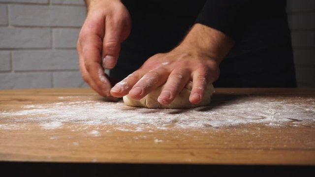 Fast motion footage of dough kneading by chefs strong hands