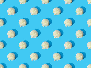 top view of whole ripe cabbage on blue colorful background, seamless pattern