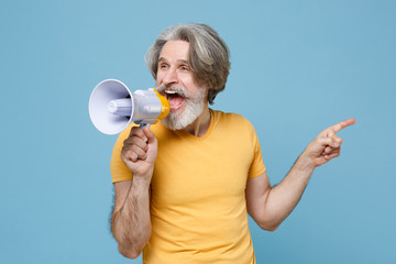Funny elderly gray-haired mustache bearded man in casual yellow t-shirt posing isolated on blue...