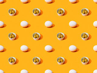 fresh white chicken eggs and olives on orange colorful background, seamless pattern